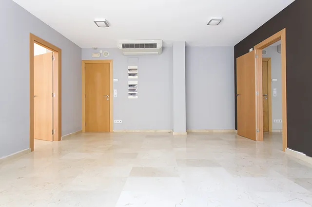 Espacio diáfano con suelo de mármol y varios accesos a despachos